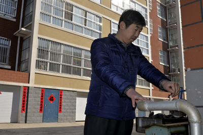 耿遵珠在查看秸秆燃气管道。（图片来源于网络）