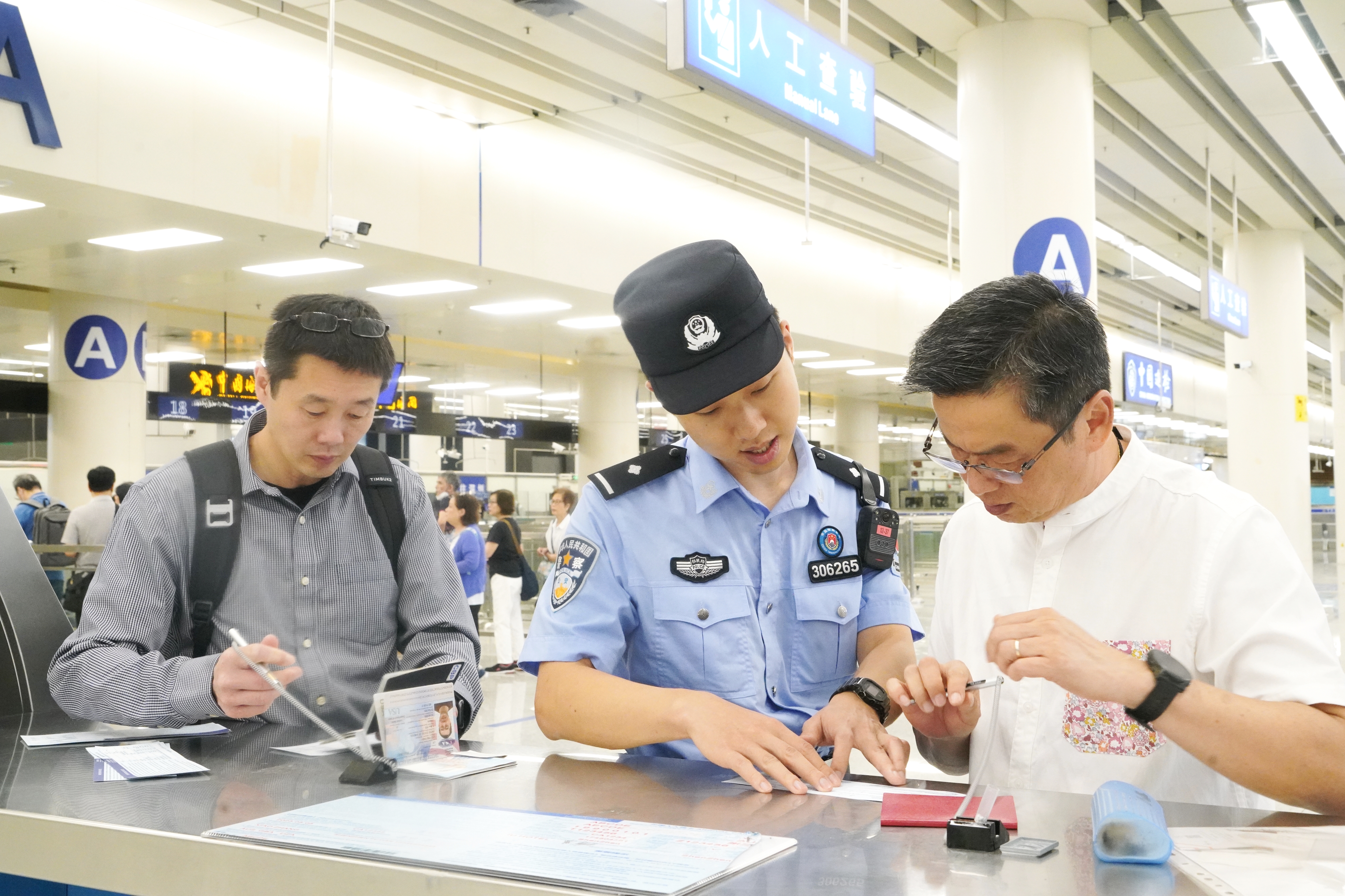 皇岗边检站民警帮助外国商客填写入境卡。（来源：皇岗边检站）.jpg