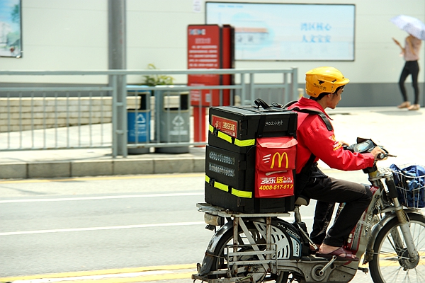 麦当劳的送餐员迎着烈日送餐.
