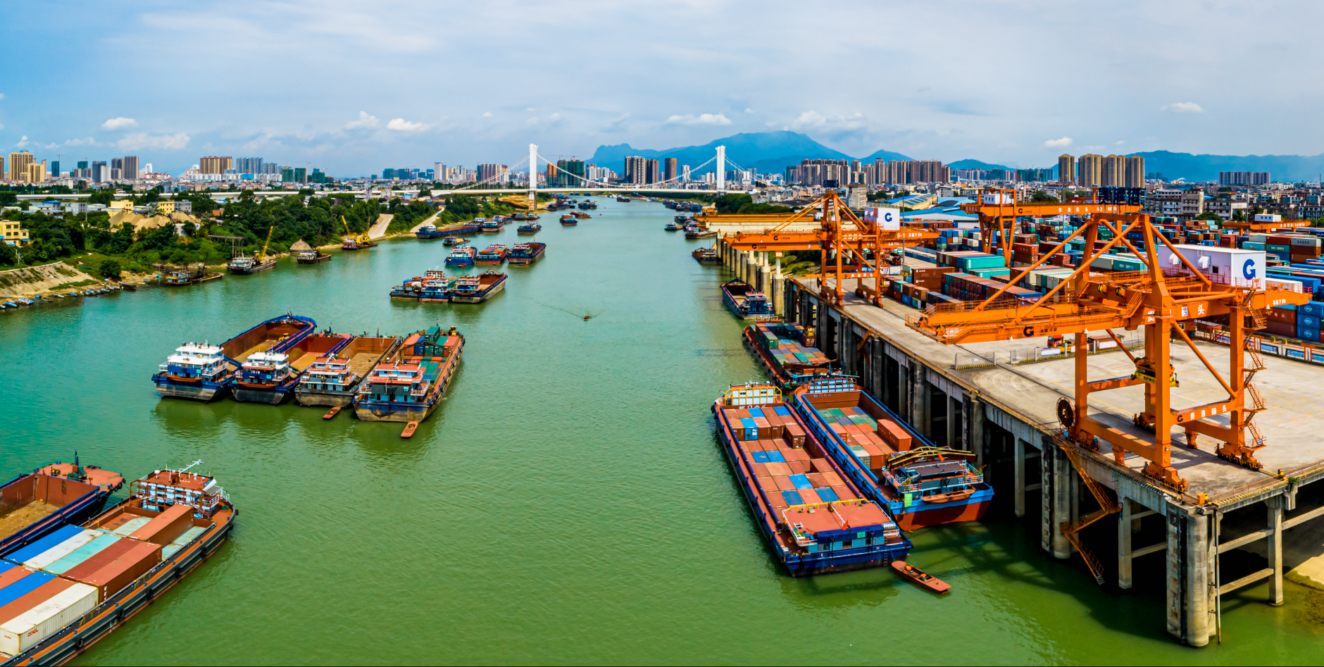大货车频繁出入,吊机有序地装卸货物,这是在北部湾港贵港集装箱码头