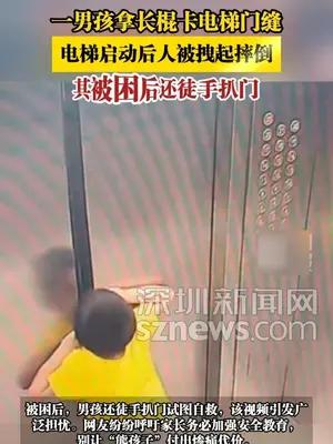 一男孩拿长棍卡电梯门缝，电梯启动后人被拽起摔倒