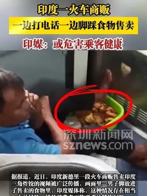 印度一火车商贩一边打电话一边脚踩食物售卖