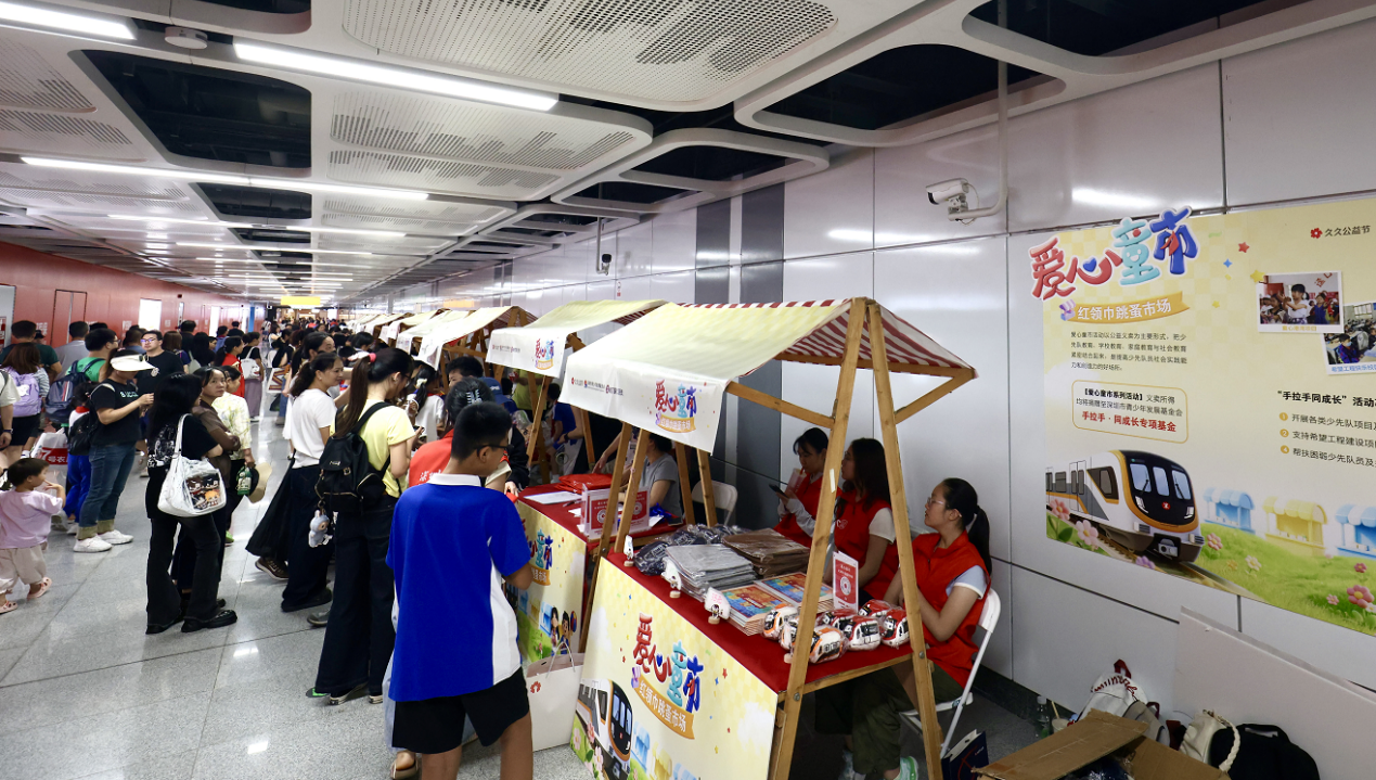 地铁站里摆起“爱心摊位”，红领巾“小摊主”义卖筹款帮扶“手拉手”学校